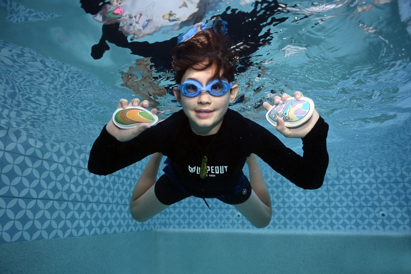 diving underwater to get te reo pool toys paua kutai