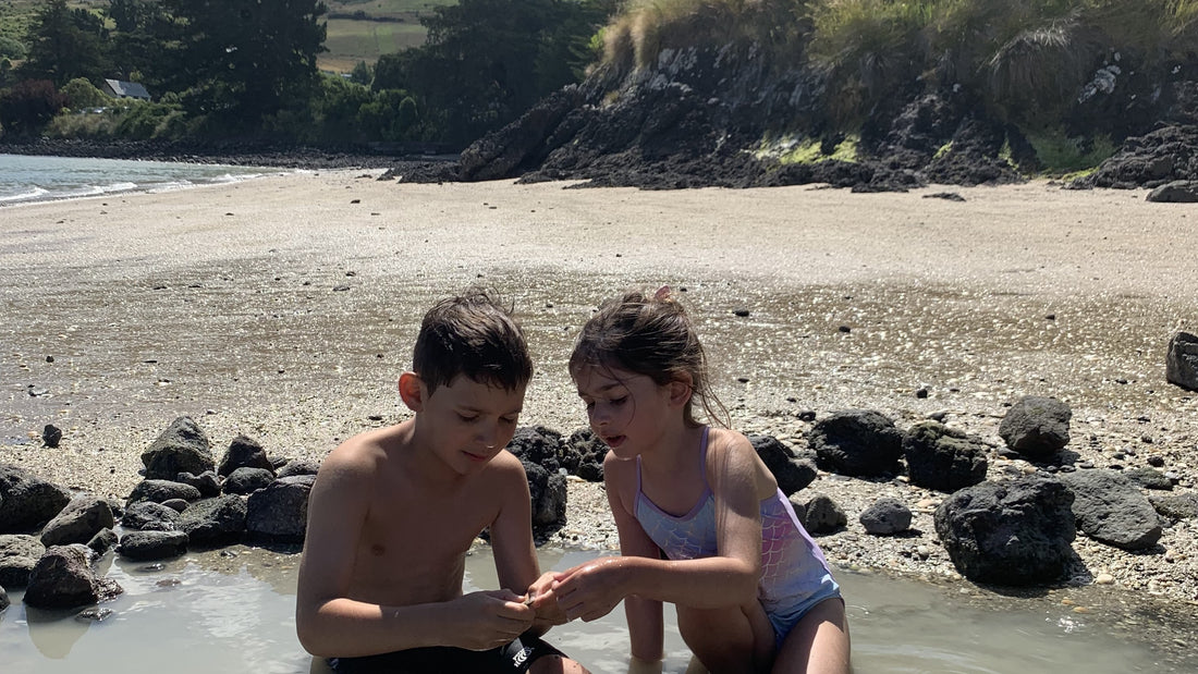 Tamariki children exploring hot springs at Rapaki Bay, New Zealand 